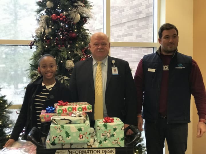 Eighth-grader Paige Pray, left,  donated toys with Ryan Accurso, center, of the Boys and Girls Club of Greenwich as Greenwich Hospital CEO Norman Roth looks on.