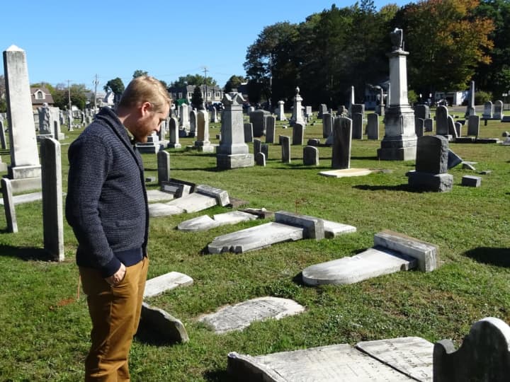 Pastor Andy Kadzban of the Wyckoff Reformed Church surveys the damage done to century-old headstones in the church’s cemetery.