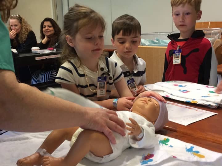 Anna Forler learns how to wrap a newborn during Take Your Daughters and Sons to Work Day at Greenwich Hospital.