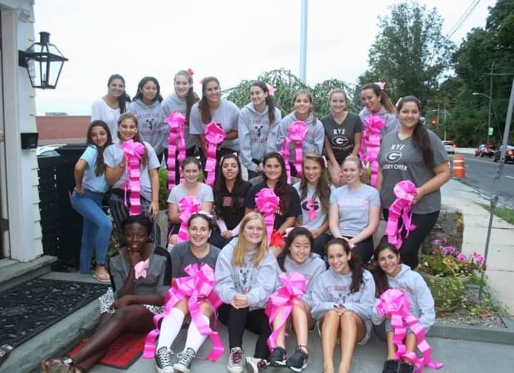 Rye cheerleaders with pink ribbons.