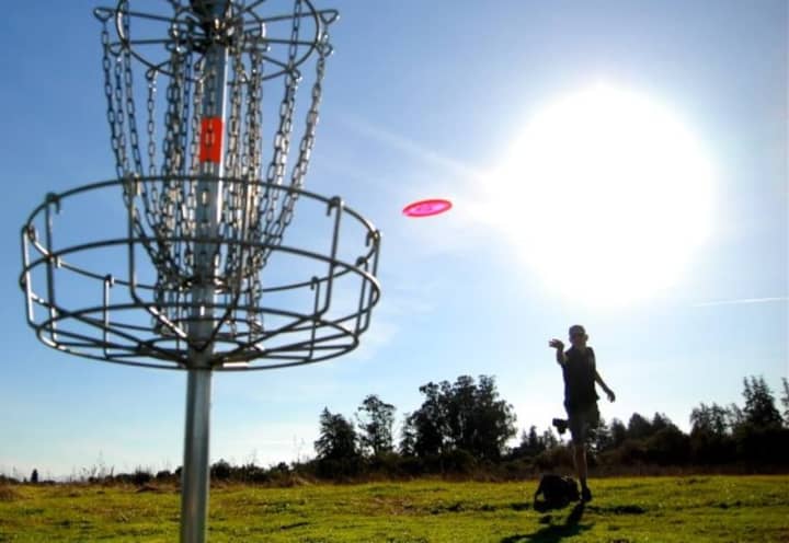 Disc golf is played by throwing golf discs into baskets attached to poles.