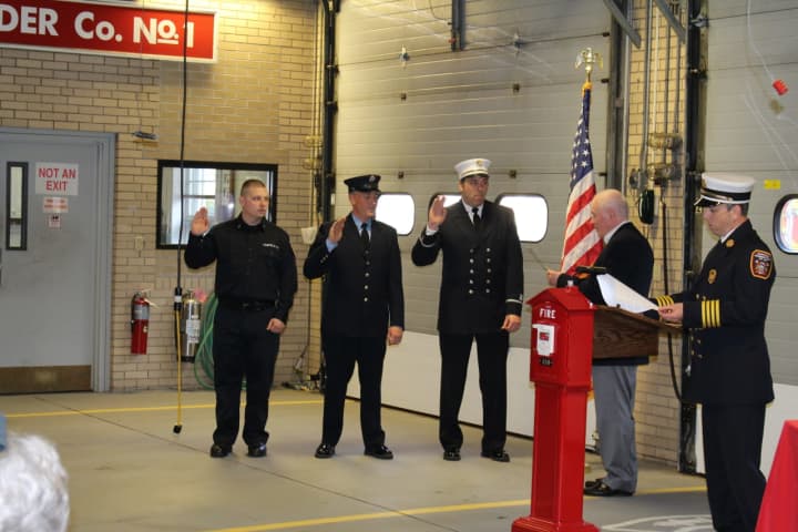 First Selectman Mike Tetreau (second from right) administers the oath of office to (left to right) Firefighter Justin Crawford, Lieutenant Kevin Polcer and Assistant Chief Roger Caisse.