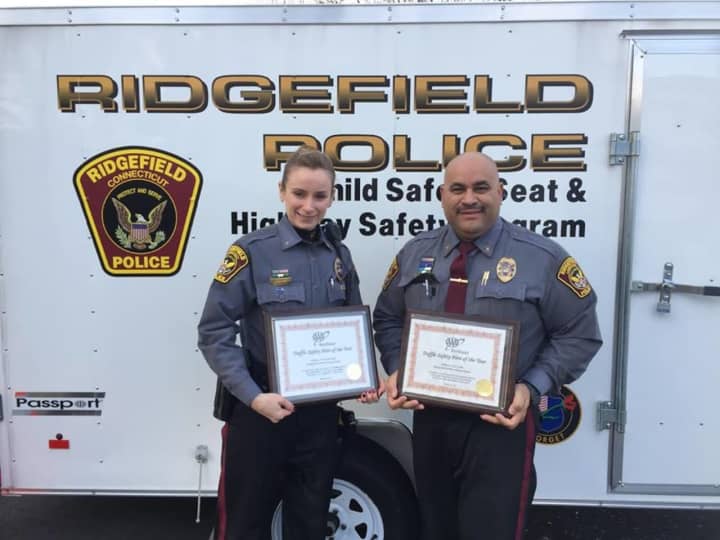 Ridgefield police Officers Victoria Ryan and Lou Caba show off the American Automobile Association (AAA) awards that they received for their contributions to traffic safety.