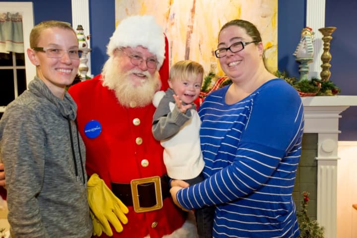Santa Claus with 3-year-old RIley and his mothers, Amy Manning Burns, left, and Tara Burns of Yorktown. Santa delivered the news that Riley, who is battling Leukemia, was granted his wish to visit Disney World and meet Mickey Mouse.