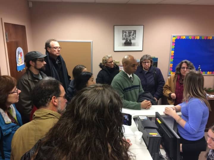 Michael Lockett of Rockland United, center in green sweater, talks with Allison Biasotti, regional director for Charles Schumer, at the senator&#x27;s Peekskill office Tuesday. The group was concerned over his voting to confirm several Cabinet picks.