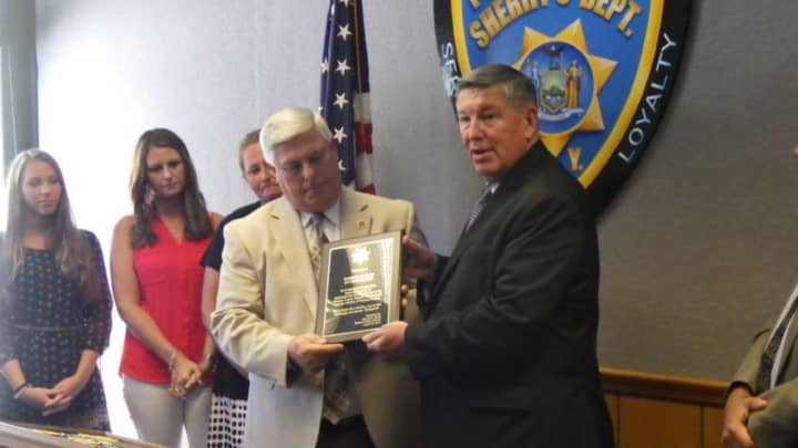 Putnam County Sheriff’s Investigator Robert Ferris, left, receives plaque from Sheriff Donald B. Smith. 