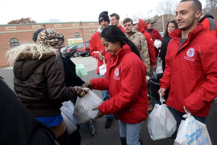 Students from Sacred Heart University distribute food for Thanksgiving meals at St. Charles Borromeo in Bridgeport, Conn.