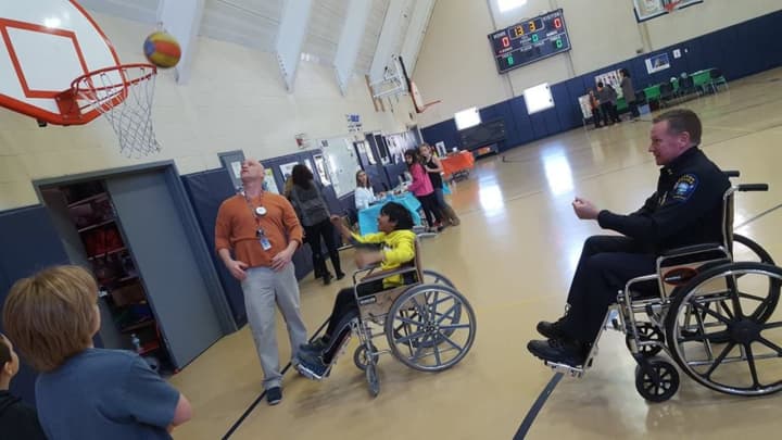 Easton Police Chief Tim Shaw tries his hand at wheelchair basketball during &quot;Diversity Day&quot; at Samuel Staples Elementary School.