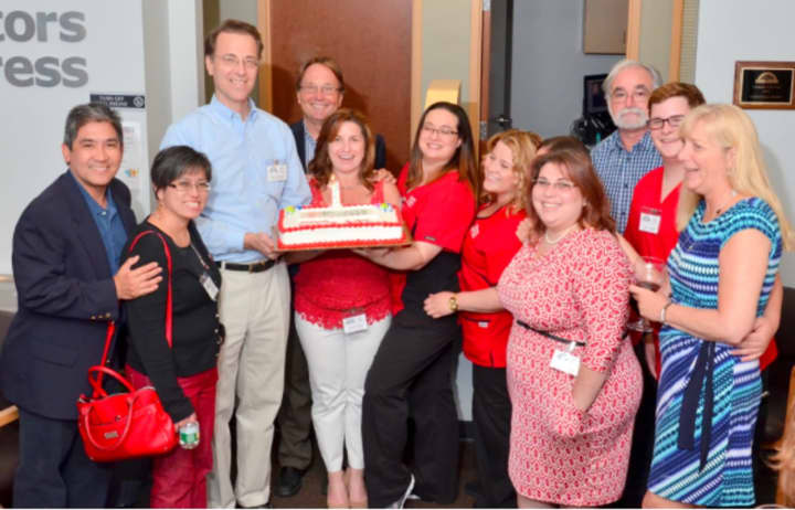 AFC/Doctors Express owner Brad Radulovacki (in blue shirt), staff and guests celebrate the urgent care center’s one-year anniversary in Stamford on June 17.