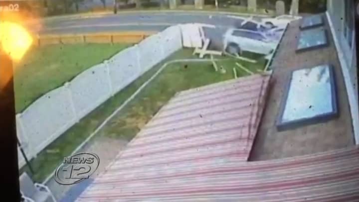 A security camera image of the driver smashing through an Eastchester fence before striking the house. 