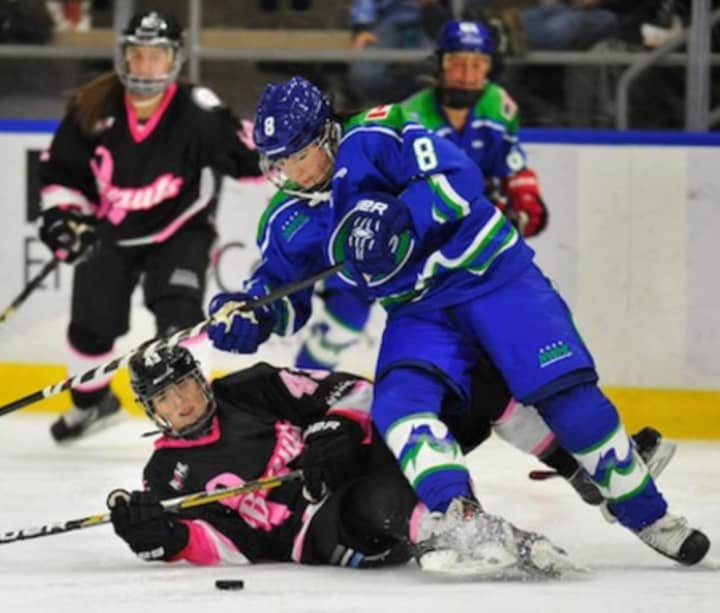 Kelly Babstock of the Connecticut Whale fights for the puck as a Buffalo Beauts player lies on the ice. The Stamford-based Whale are in first place in the four-team National Women&#x27;s Hockey League.