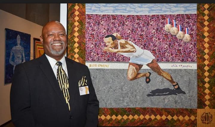 Julius Bremer stands by his quilt of Olympic legend Jesse Owens. The quilt will be on display at Bruce Museum in Greenwich beginning next month as part of &quot;And Still We Rise: Race, Culture, and Visual Conversations,&quot; which runs until April.
