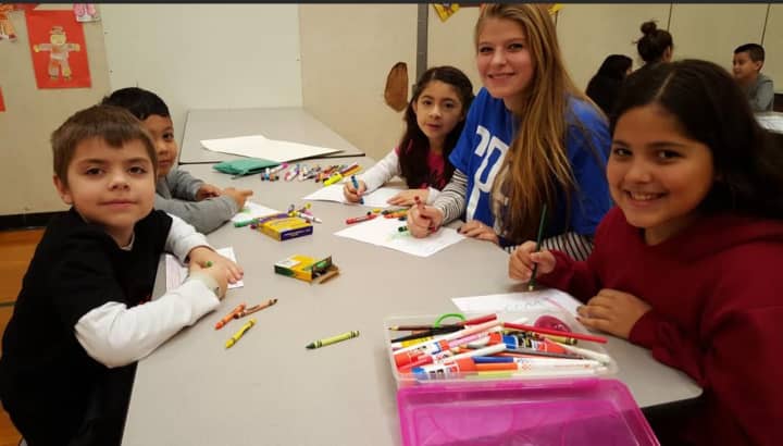 Students from the Roxbury and Julia A. Stark elementary schools in Stamford and their high school mentors make holiday cards and posters for clients of a local hospice organization