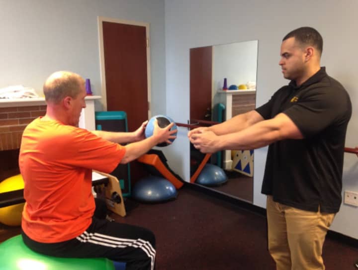 Facility Supervisor Ken Figueroa, right, instructs a member on how to perform an abdominal exercise at the Burke Rehabilitation Center&#x27;s Adult Fitness Center.
