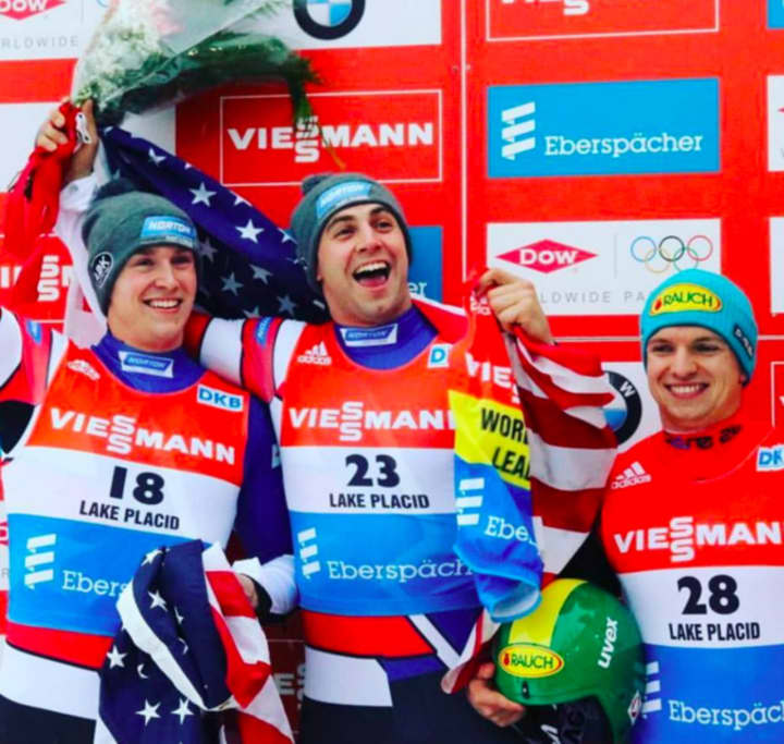 Tucker West, left, celebrates with teammates on the podium at a luge competition.