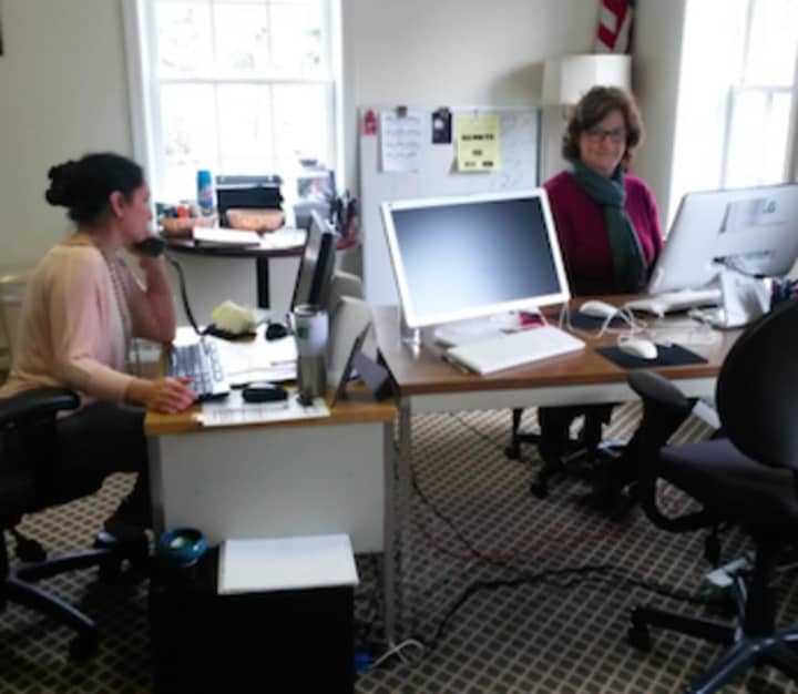 Community Answers is now located at United Way Greenwich. Pictured, at left, is Anita Lai taking a call and at right, Betsy Coons (who also volunteers for Reading Champions).