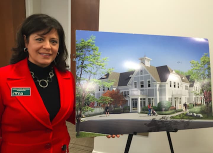 Ridgefield Visiting Nurse Association President and CEO Theresa Santoro standing beside a rendering of the RVNA&#x27;s new facility.