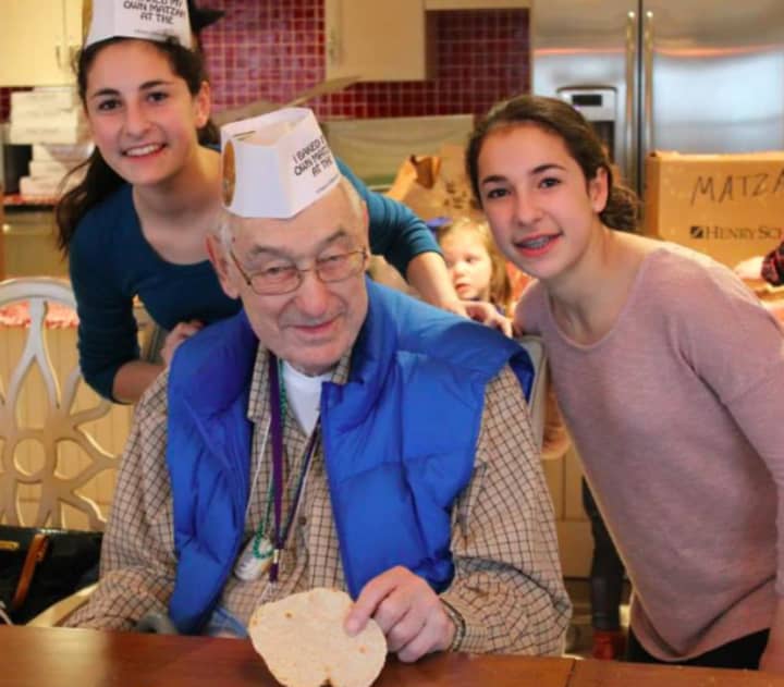 Ridgewood twin sisters Hanna and Nicole Kaplun, volunteers in Valley Chabad&#x27;s Cteen program participate in the previous year&#x27;s Passover event at the Bristal in Woodcliff Lake with Bernie Turner.