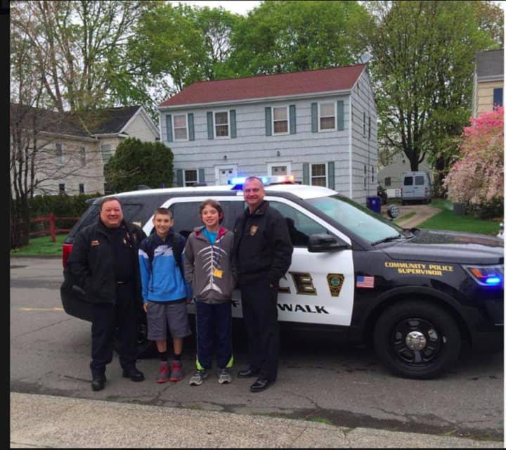 Two students got a ride to school with Norwalk Police Chief Thomas Kulhawik and Deputy Chief Ashley Gonzalez.