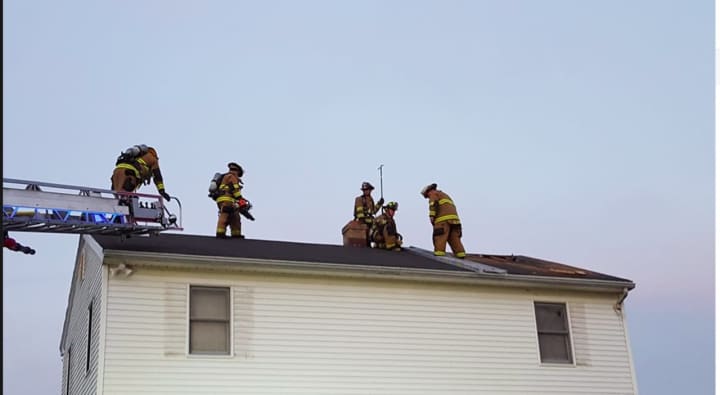 Members of Shelton Fire Companies train on the roof of a demo house.