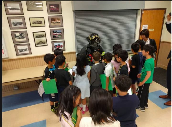 Members of Greenwich Firefighters Engine 4 with a group of students from the Japanese School of Greenwich.