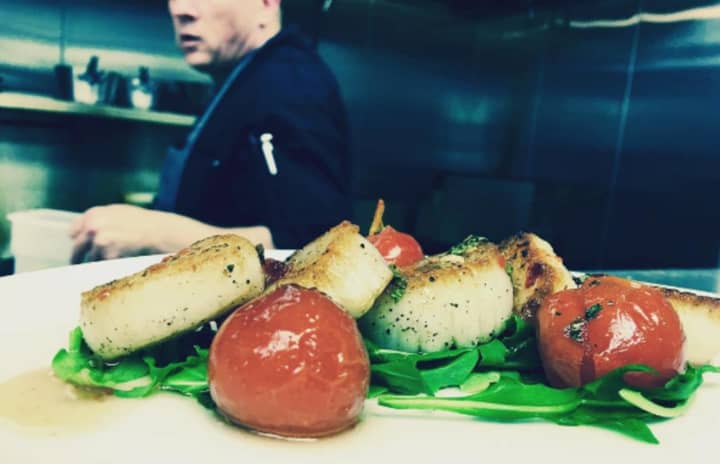 White Maple Cafe chef Bian McGackin whips up pan-seared scallops fresh from Montauk with tomatoes and mint. tossed in honey chili dressing and served on a bed of arugula.