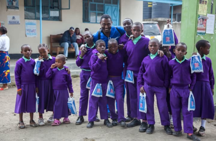 Dr. Alain Auguste meets boys in Tanzania, where he spent four days helping residents there with dental needs. Auguste works for Aspen Dental in Fairfield.
