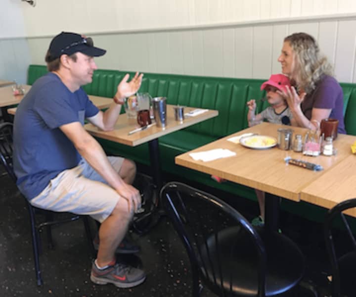 U.S. Sen. Chris Murphy speaking with Fairfield resident Abigail Lorge and her daughter Eliza at the Driftwood Café in Southport Friday. Murphy is walking across the state to speak with his constituents.