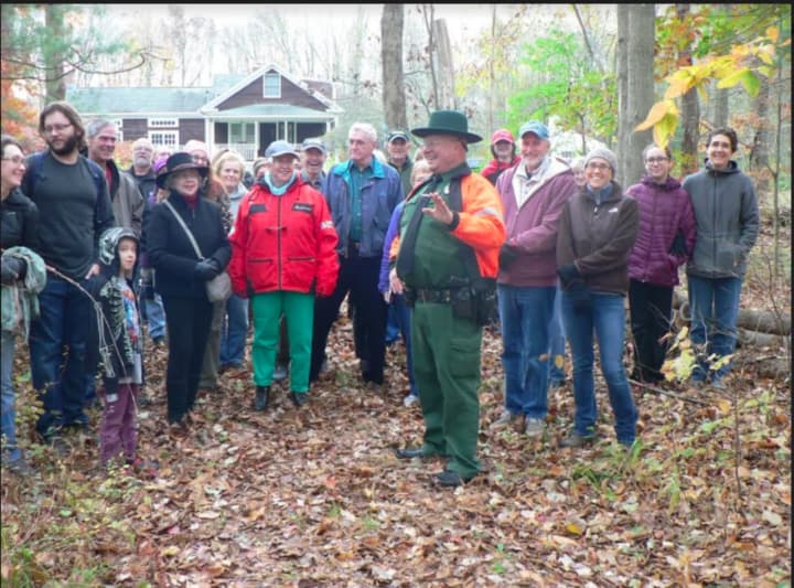 David Solek, right. (in green), Monroe’s park ranger and tree warden, addresses  his hiking group during the Monroe Halloween Fall Foliage Creepy Cemetery Tour.