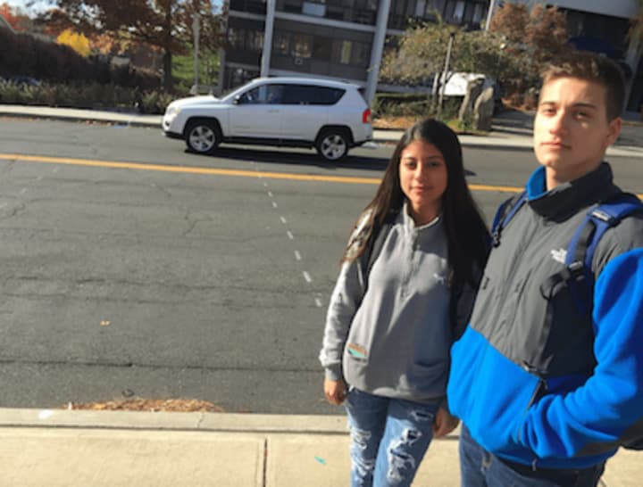 Stamford High students Mariana Jimenez and Fabio Luco, stand on the sidewalk in front of Stamford High School. The markings on Strawberry Hill Avenue show where a crosswalk will be located. The city is putting the crosswalk following a student death.