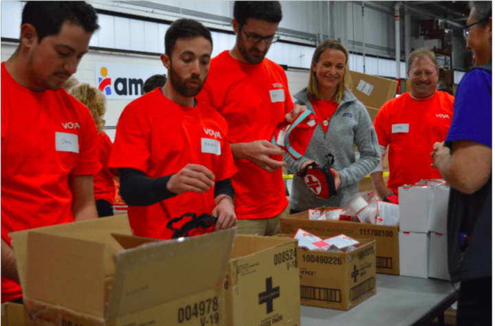 One by one, in assembly line fashion, about 30 volunteers from Voya Financial assembled first aid kits on Tuesday morning at Americares headquarters in Stamford, to celebrate Giving Tuesday.