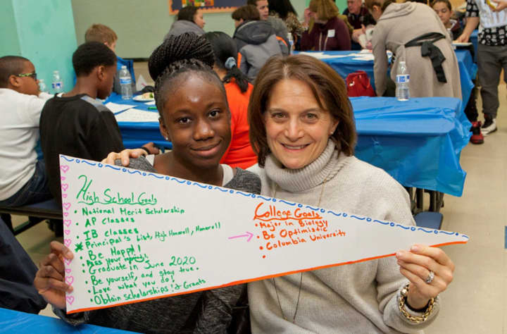 Ninth-grader Agyeiwa Okodie and her graduation coach, Susan Roth, hold a banner showing the student&#x27;s goals at a recent Yonkers Partners in Education event celebrating incoming program participants.