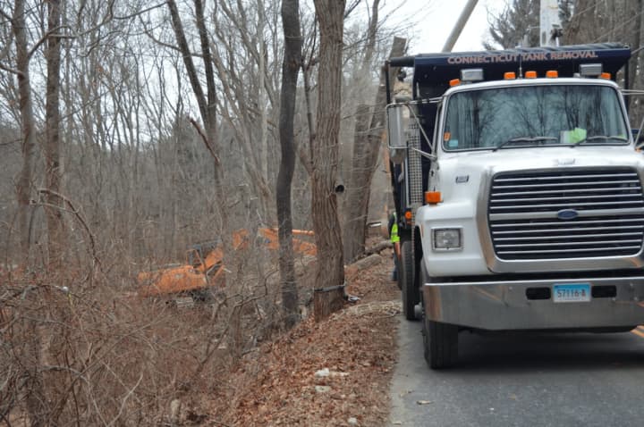 Crews work on cleanup Tuesday after a truck crash caused nearly 2,000 gallons of oil to spill onto Judd Road in Monroe near the Easton border on Monday.