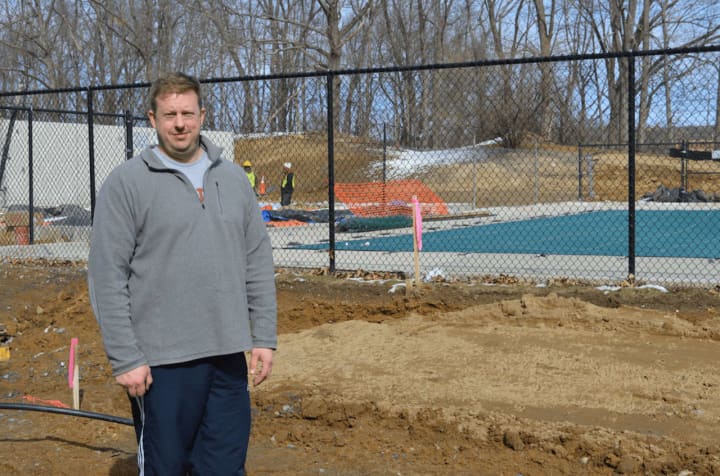 Jason Paige, senior aquatics director and coach of the Regional YMCA Mako Swim Club, standing beside the new Youth Development and Aquatic Center that’s being constructed at the Regional YMCA of Western Connecticut in Brookfield.