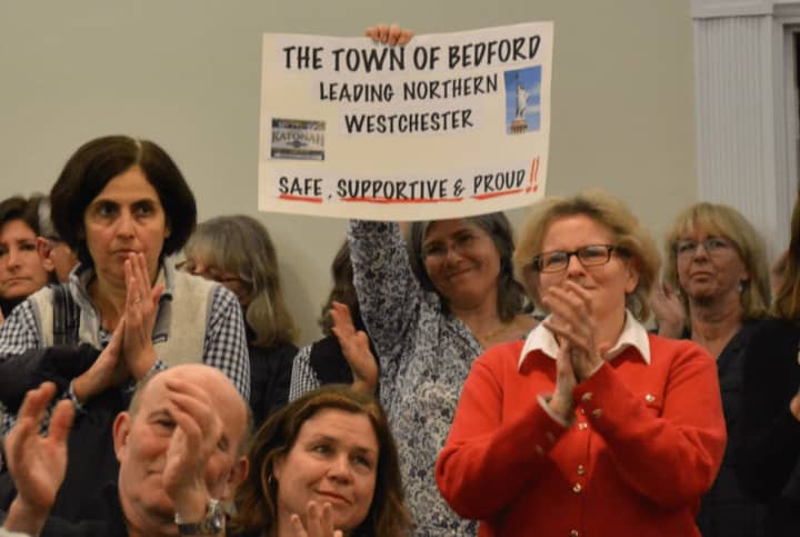 Residents give applause after the Bedford Town Board adopted a resolution on immigration policy.