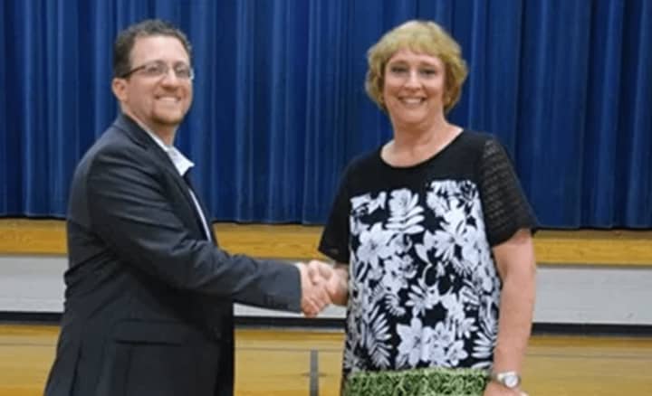 Scott Clough, left, the new principal at St. Mark School in Stratford, shakes  hands with his predecessor, Donna Wuhrer, who retired from the position after three years as school leader.