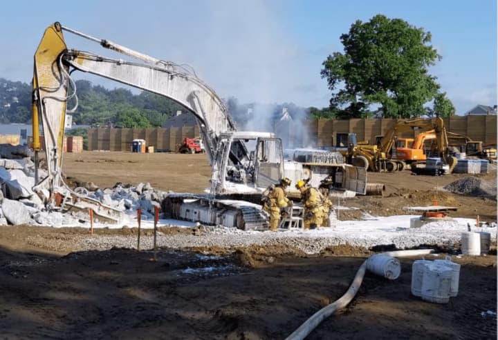 Fire crews used foam to put out a burning excavator at the Home Depot construction site in Stamford on Saturday morning.
