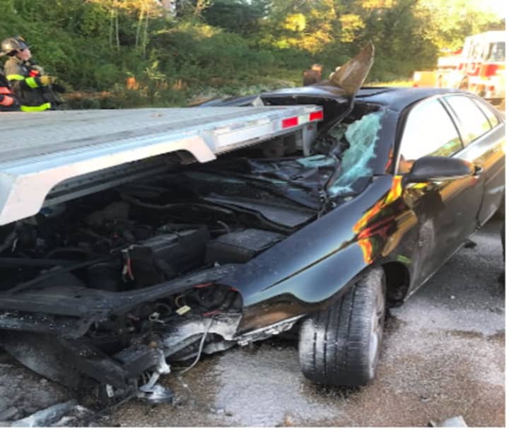 A sedan slammed into the back of the flatbed of a tractor-trailer that was parked near the Exit 2 on ramp of I-84 eastbound during the Friday morning rush hour.