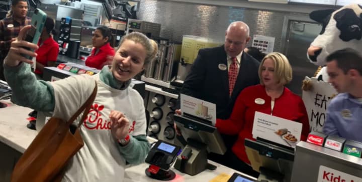 And they&#x27;re open! One of the first customers at the new Chick-Fil-A in Norwalk snaps a selfie as she gets her breakfast on Thursday at the grand opening.