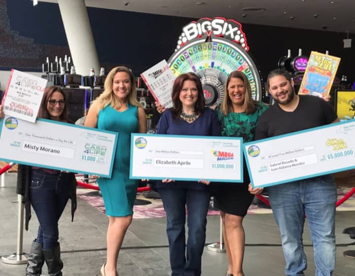 New York Lottery winners from Westchester hold their checks.