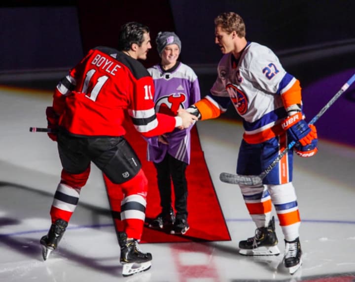 Burgida, 11, drops the ceremonial first puck Friday for NJ Devil Brian Boyle and NY Islander Anders Lee.