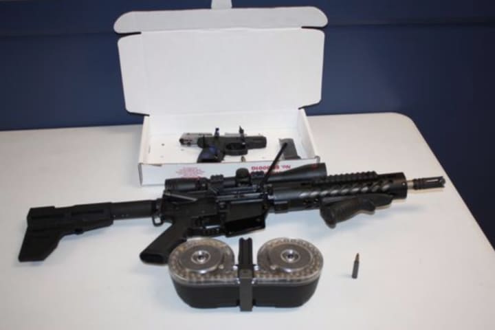 A truck driver from Florida was busted with an illegal assault rifle, 9mm handgun and several high-capacity magazines.