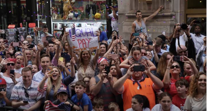 A woman attending the Canyon of Heroes parade in Manhattan holds up an &quot;Equal Pay&quot; sign.