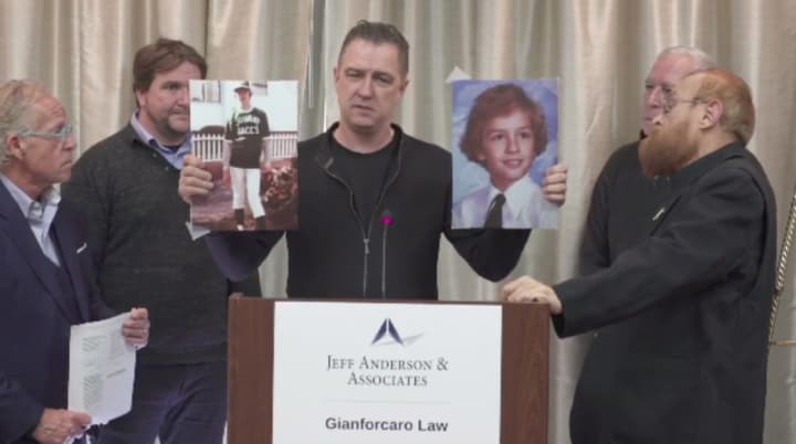 The suits were filed by Stephen Tyminski, now a 66-year-old Orthodox priest in Queens, and Keith Mozian, 56, of Califon. Stephen Marlowe, 48, holds photos of and speaks on behalf of Mozian, who couldn&#x27;t be at the conference.