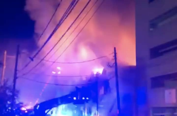 A four-alarm fire heavily damaged several apartments and businesses on Long Island.
