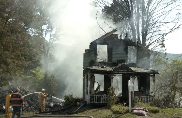 A woman was killed when a dump truck slammed into an Ashland home, sparking a massive fire Wednesday, June 15.