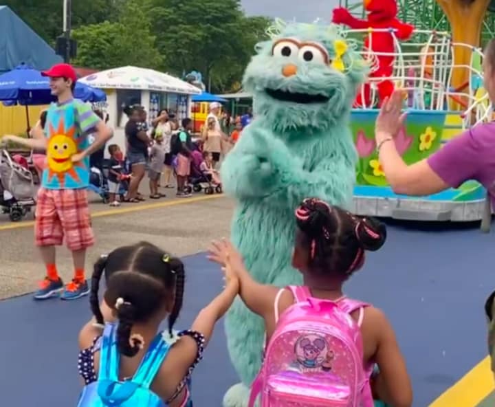 The video shows the two girls waiting with their hands out for high fives or a hug from the green fluffy character at the Langhorne, PA theme park, who looks at them and shakes his head no, leaving the girls seemingly confused and sad.