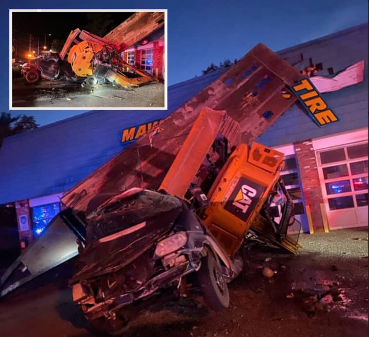 A black pickup truck towing an excavator flipped and crashed into Mavis Tire in Sparta, authorities said.