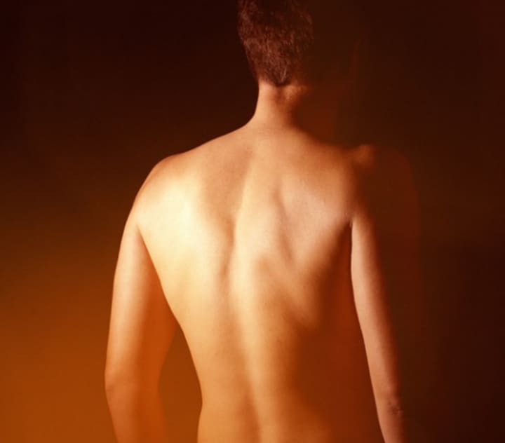 A naked man&#x27;s back.