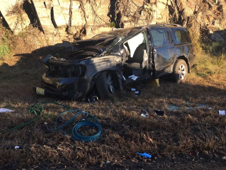 A black SUV rests against a rock wall after crashing on Route 8 on Friday morning in Shelton. Three people inside had to be extricated by emergency crews. The morning commute was a tough one as traffic was backed up for miles.
